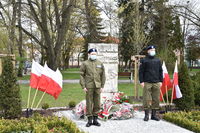 Obsługa mundurowa stoi przy pomniku Konstytucji 3 Maja pod którym leżą wiązanki kwiatów, w tle drzewa.JPG