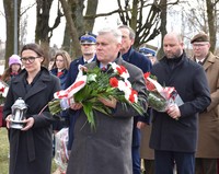 Delegacja Powiatu Płońskiego (kobieta i mężczyzna) składa kwiaty i znicz.