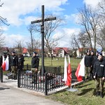 Krzyż, po prawej i lewej stronie stoją flagi Polski, w tle uczniowie klas mundurowych.JPG