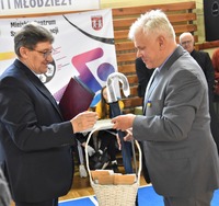 Przewodniczący Dariusz Żelasko wręcza upominki ks. Zbigniewowi Sajewskiemu.