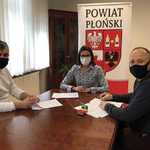 Starosta i przedstawiciele UKS Korsarz Płońsk siedzą przy stole w gabinecie Starosty i podpisują umowę.jpg