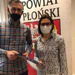 Starosta Płoński i przedstawiciel Football Academy Płońsk stoją na tle rollupa z herbem i napisem powiat płoński.jpg