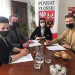Starosta Wicestarosta i Skarbnik Powiatu siedzą w gabinecie Starosty i podpisują umowę z przedstawicielem Stowarzyszenia Płońscy Patrioci